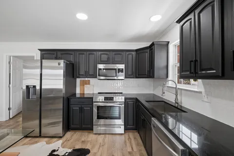 a kitchen with stainless steel appliances wooden cabinets and granite counter tops