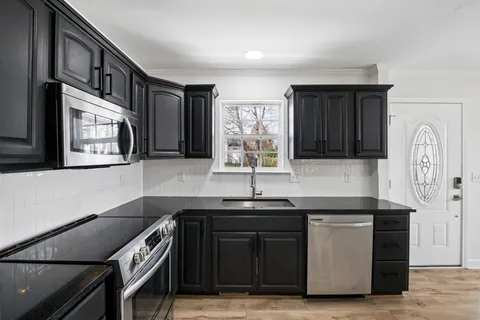 a kitchen with stainless steel appliances granite countertop a sink and a stove