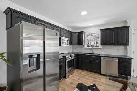 a kitchen with stainless steel appliances granite countertop a refrigerator and a sink
