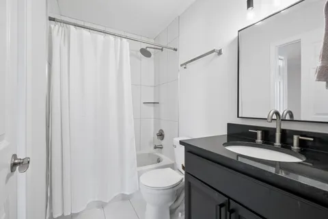 a bathroom with a granite countertop sink toilet and shower