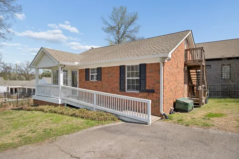 a view of a house with a backyard and porch