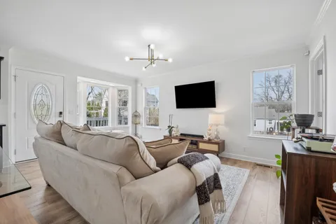a living room with furniture a large window and a flat screen tv