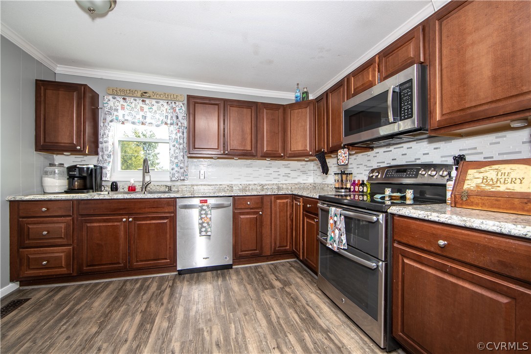 16907 Courthouse Road Dinwiddie, VA 23841 - Photo 5 of 15 a kitchen with stainless steel appliances granite countertop wooden cabinets a stove top oven a sink and dishwasher with wooden floor
