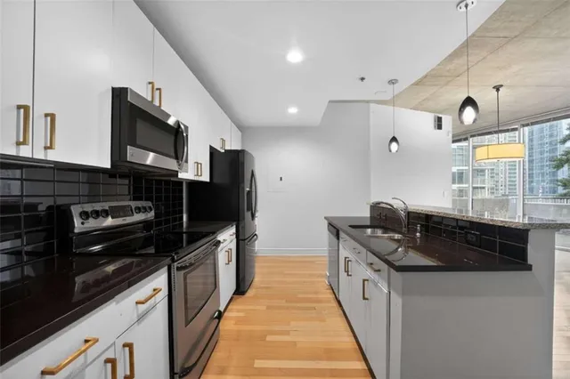 a kitchen with stainless steel appliances granite countertop a stove a sink and a refrigerator