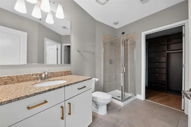 a bathroom with a granite countertop sink a toilet and shower