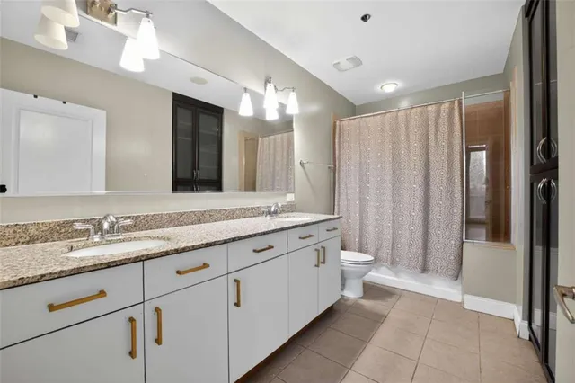 a bathroom with a double vanity sink and mirror with shower