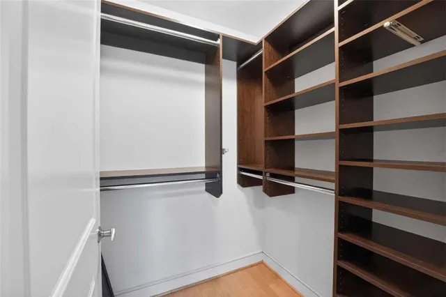 a view of walk in closet with empty racks