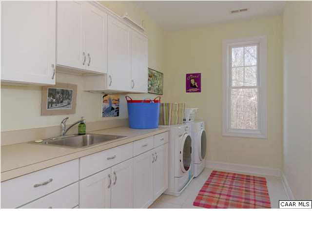 1441 Stillhouse Ridge Lane Charlottesville, VA 22903 - Photo 21 of 32 a kitchen with a sink dishwasher and white cabinets with wooden floor