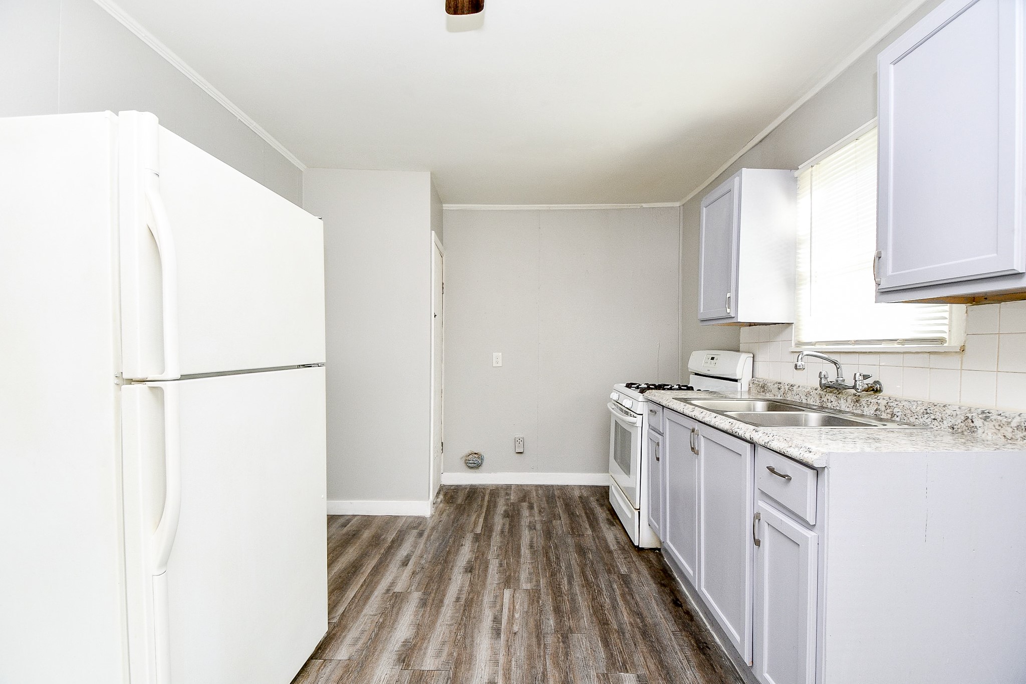 5000 Noble Street, Unit 6 Houston, TX 77020 - Photo 8 of 21 a kitchen with a sink a refrigerator a stove and white cabinets