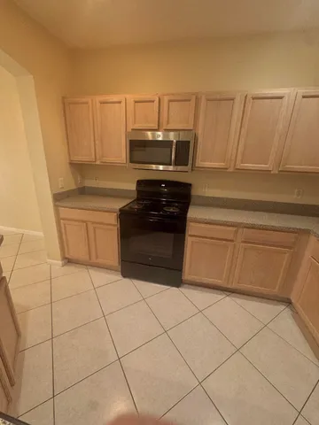 a kitchen with white cabinets and appliances
