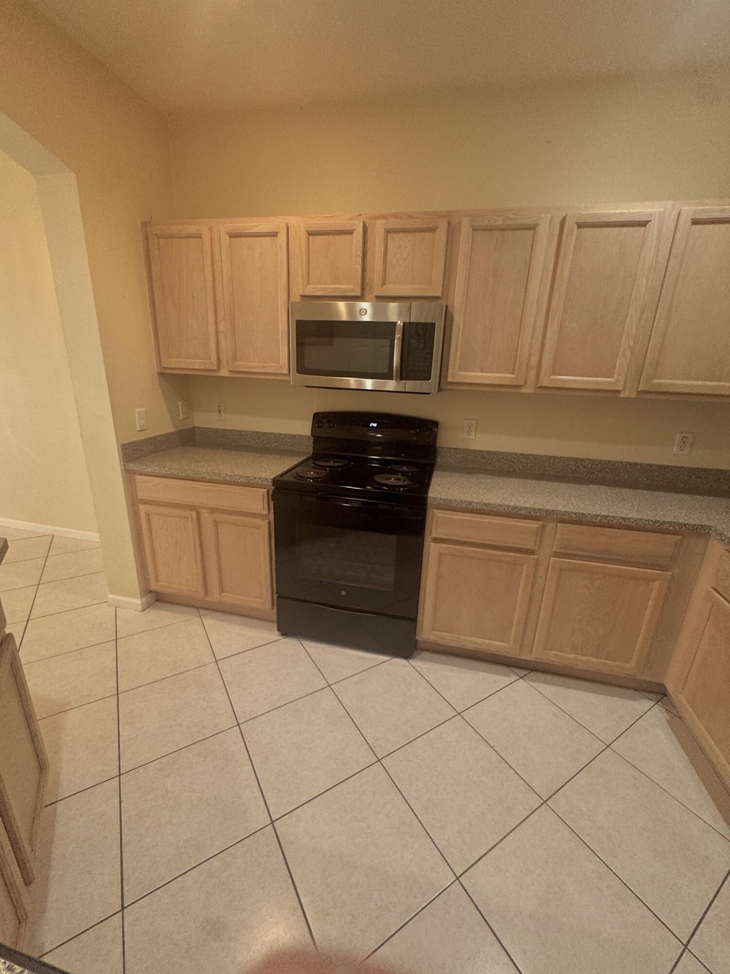 8171 Bellagio Lane Boynton Beach, FL 33472 - Photo 4 of 10 a kitchen with white cabinets and appliances