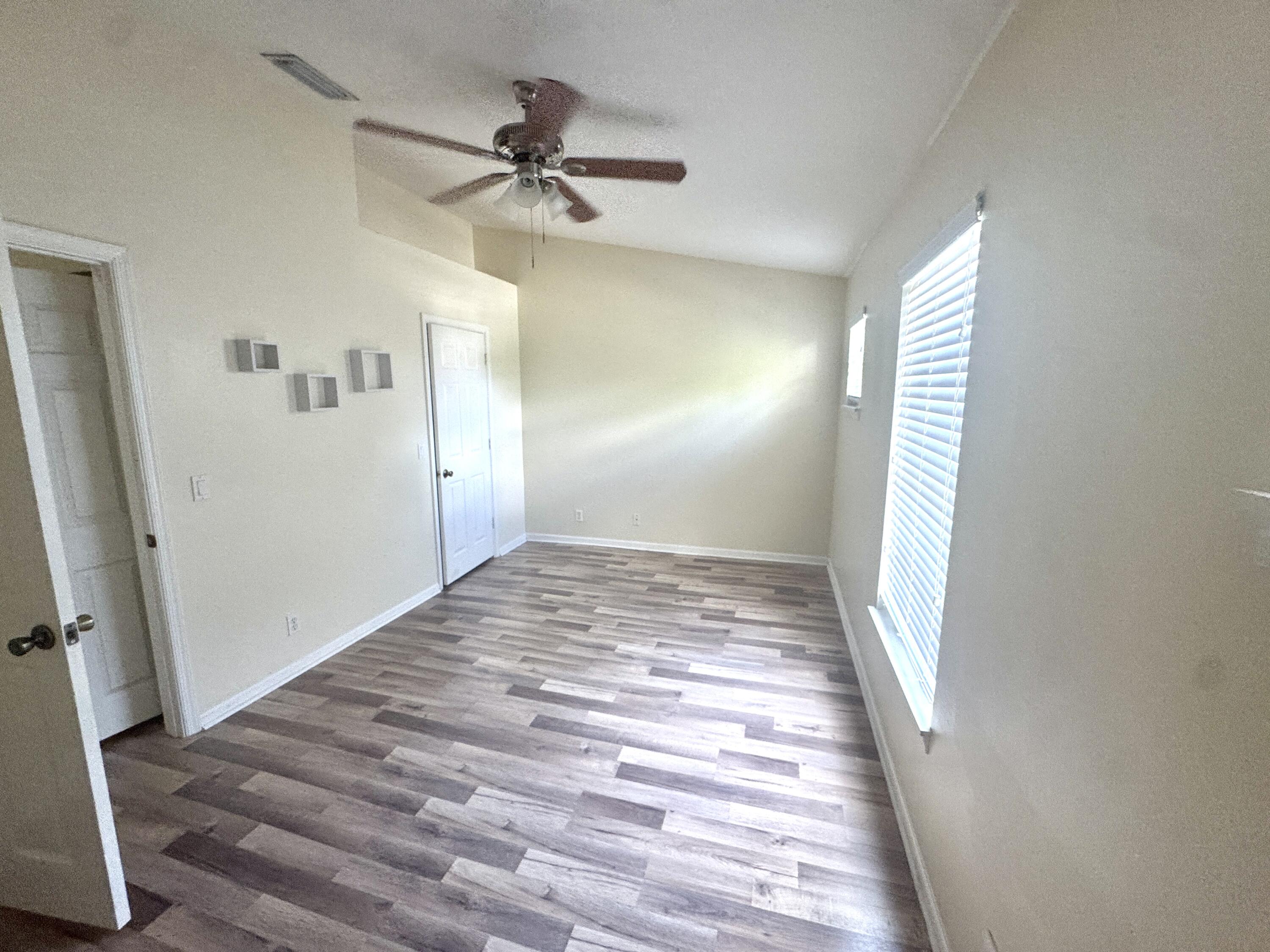8171 Bellagio Lane Boynton Beach, FL 33472 - Photo 6 of 10 a view of a hallway with a hardwood floor and a ceiling fan
