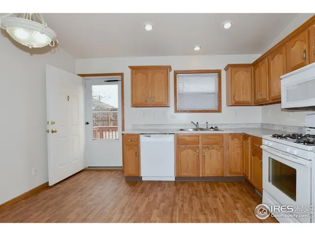 a kitchen with granite countertop a stove a sink and a microwave