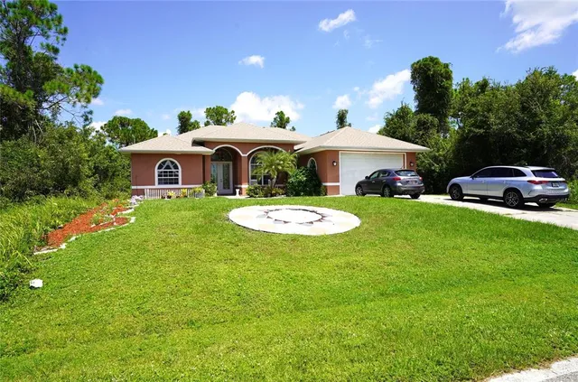 a front view of a house with a garden and trees