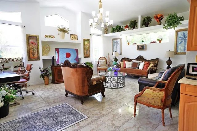 a living room with furniture a chandelier and a fireplace