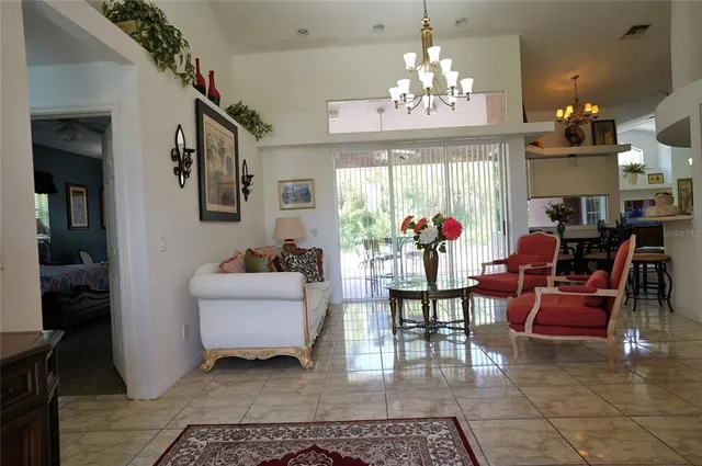 a view of a dining room with furniture a chandelier and window