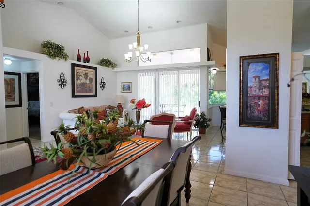 a living room with patio furniture and a chandelier
