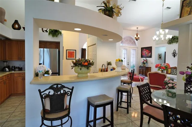 a kitchen with stainless steel appliances granite countertop a stove a sink dishwasher a dining table and chairs with wooden floor