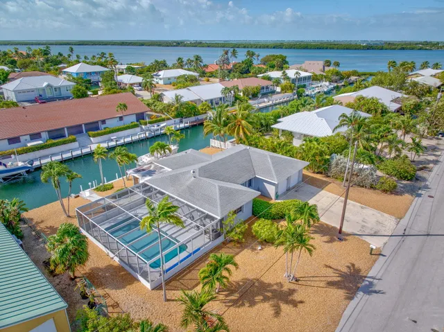 an aerial view of a house with a garden and lake view