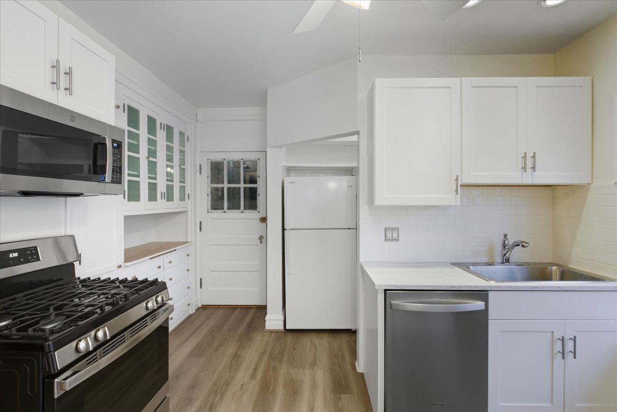1507 Dobson Street, Unit 3 Evanston, IL 60202 - Photo 5 of 14 a kitchen with cabinets stainless steel appliances and wooden floor