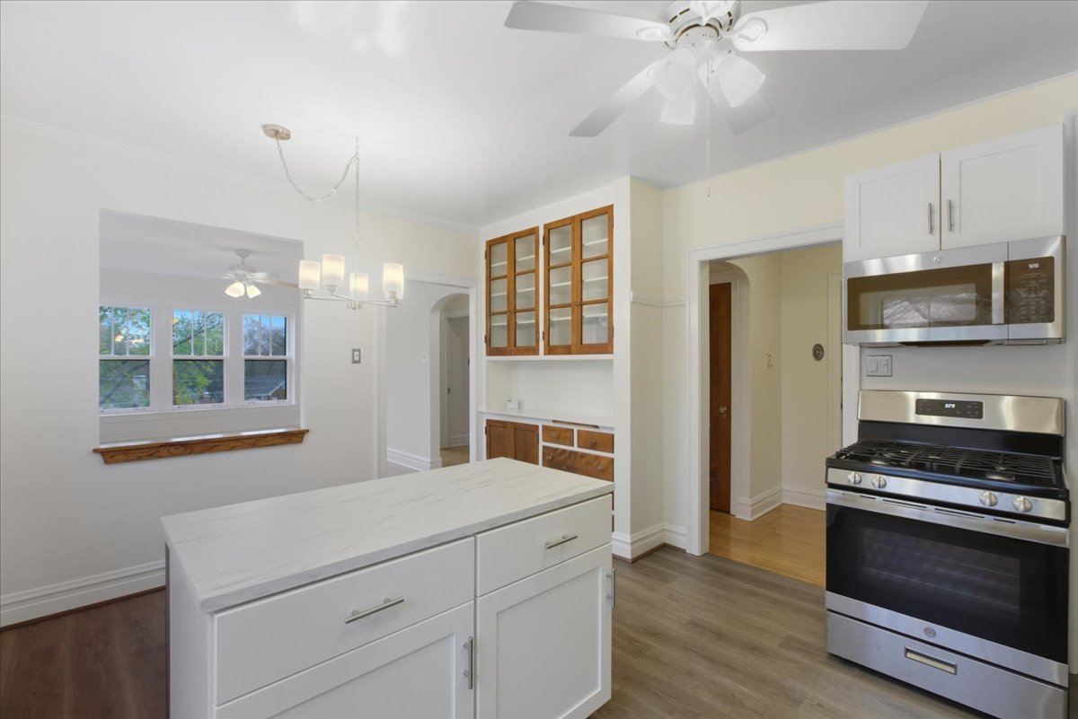 1507 Dobson Street, Unit 3 Evanston, IL 60202 - Photo 8 of 14 a kitchen with granite countertop a stove cabinets and wooden floor