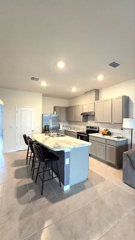 a kitchen with kitchen island a sink counter and chairs