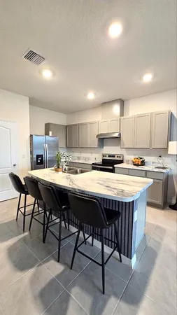 a kitchen with a table chairs sink and cabinets