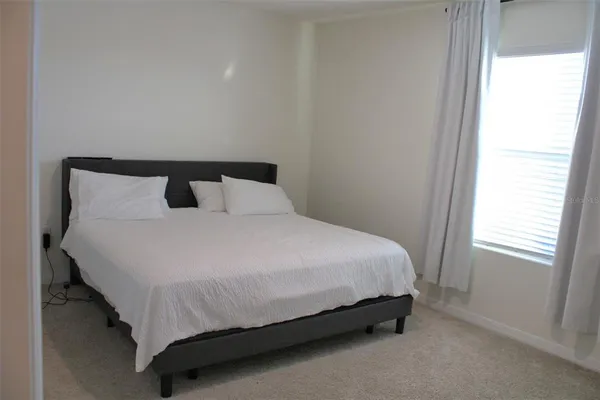 a large bed sitting in a bedroom next to a window