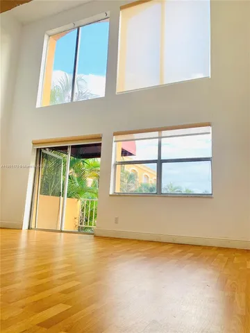 a view of a room with wooden floor and a window