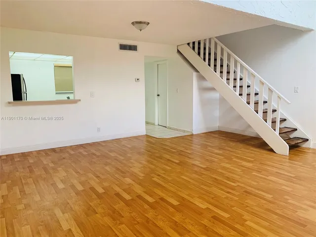 a view of a room with wooden floor and stairs