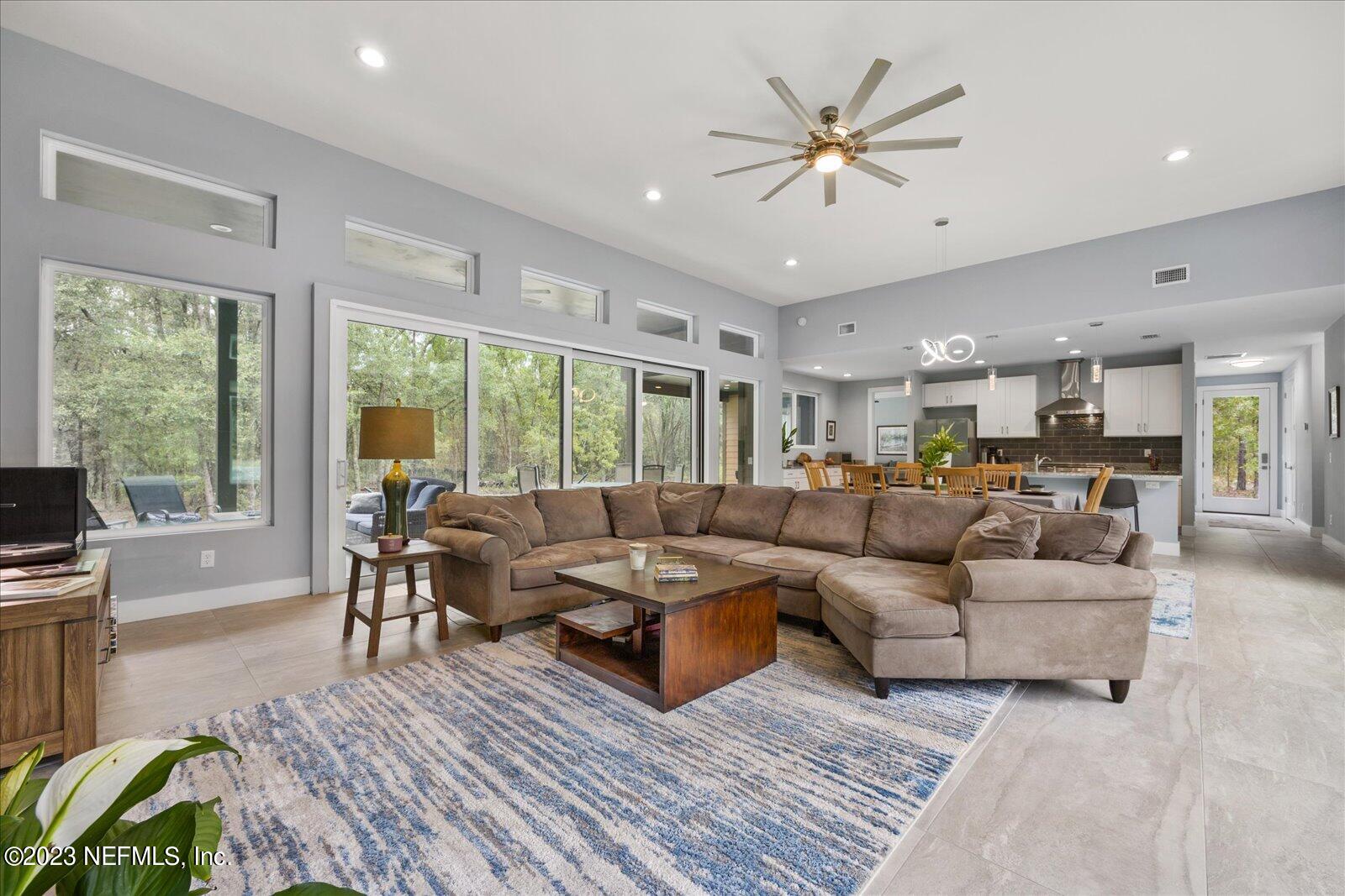 13535 Settindown Drive Bryceville, FL 32009 - Photo 13 of 59 a living room with furniture ceiling fan and a large window
