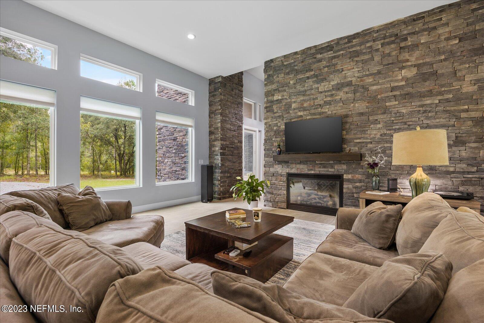 13535 Settindown Drive Bryceville, FL 32009 - Photo 14 of 59 a living room with furniture a fireplace and a flat screen tv