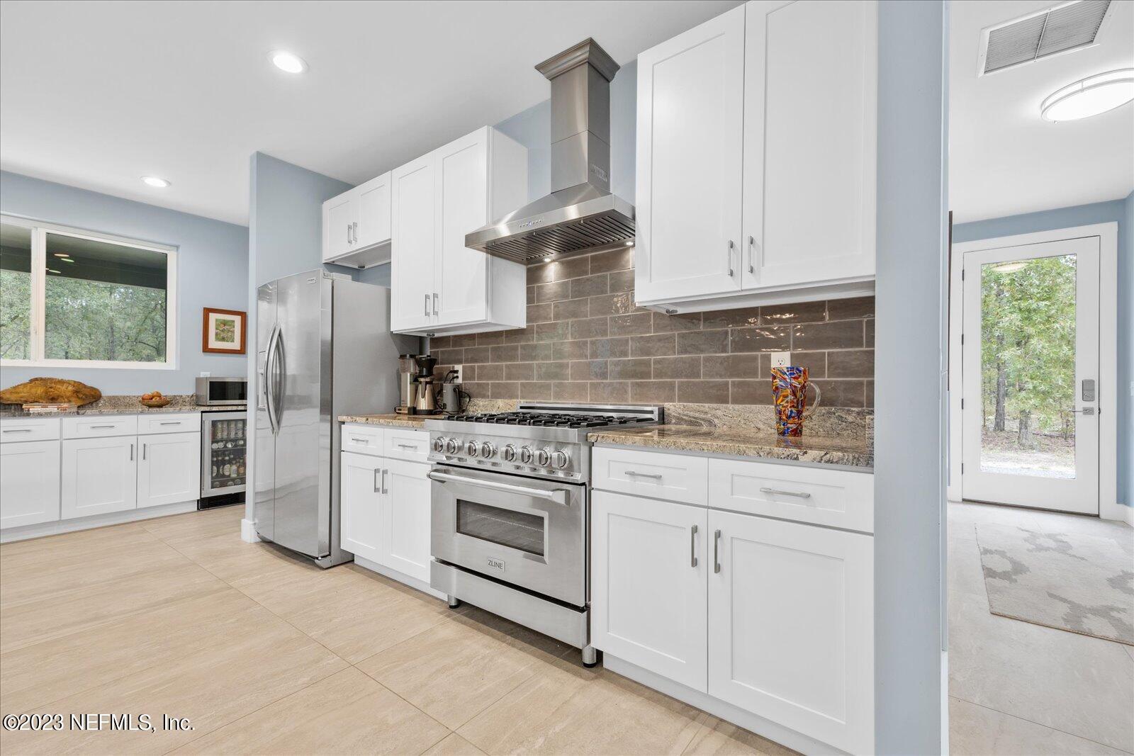 13535 Settindown Drive Bryceville, FL 32009 - Photo 24 of 59 a kitchen with granite countertop white cabinets and white appliances