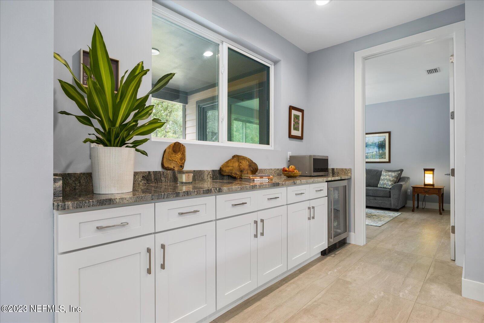 13535 Settindown Drive Bryceville, FL 32009 - Photo 26 of 59 a bathroom with a granite countertop sink a potted plant and a window