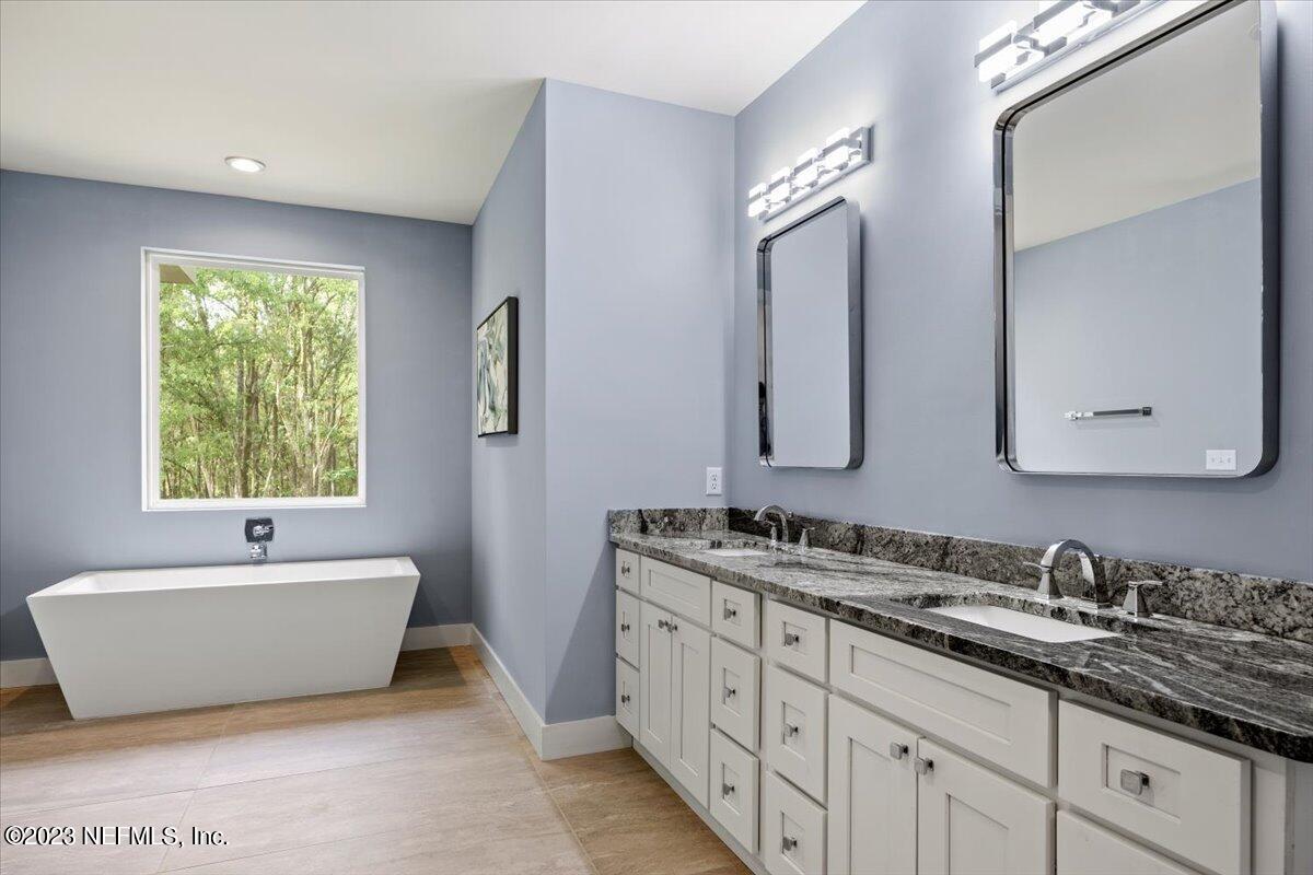 13535 Settindown Drive Bryceville, FL 32009 - Photo 32 of 59 a spacious bathroom with a double vanity sink mirror and bathtub