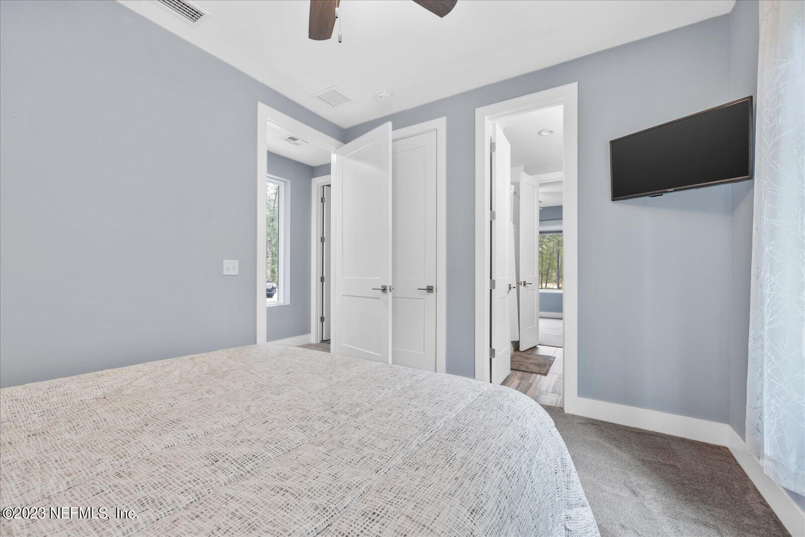 13535 Settindown Drive Bryceville, FL 32009 - Photo 34 of 59 a bedroom with a bed and a flat screen tv