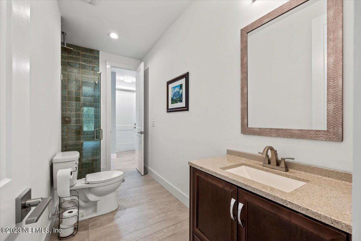 13535 Settindown Drive Bryceville, FL 32009 - Photo 40 of 59 a bathroom with a granite countertop sink a toilet and a large mirror