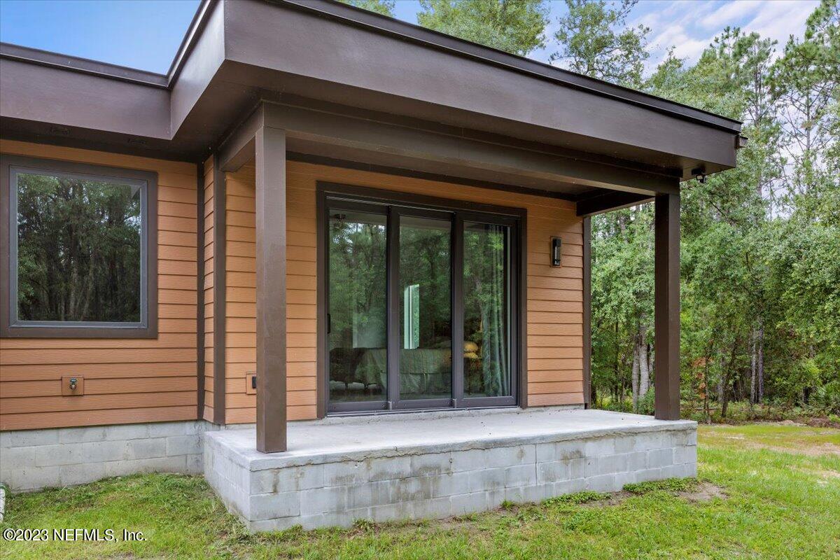 13535 Settindown Drive Bryceville, FL 32009 - Photo 49 of 59 a view of house with backyard and glass windows