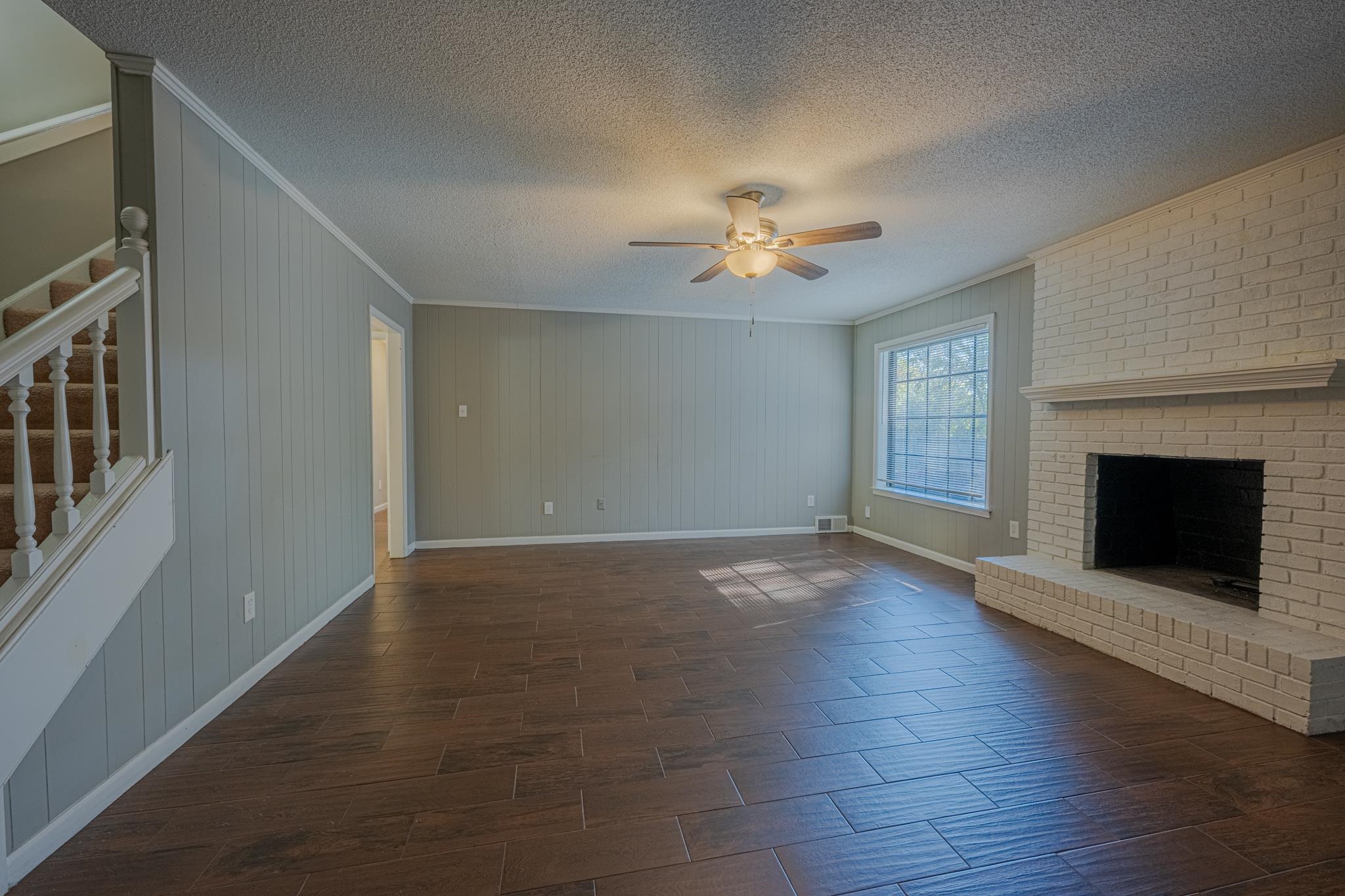 7125 Crestridge Road Memphis, TN 38119 - Photo 8 of 36 an empty room with windows fireplace and a kitchen view
