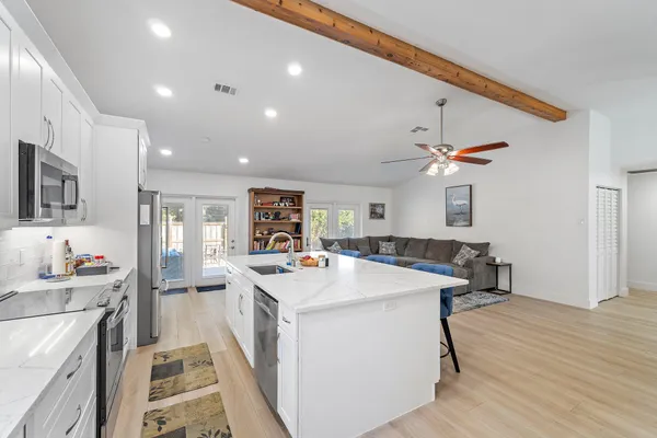 a kitchen that has a sink a stove and cabinets