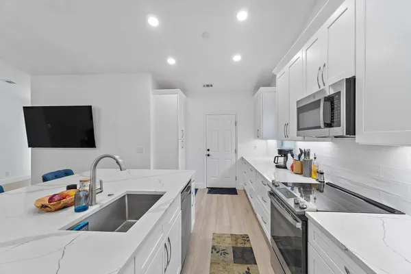 a kitchen with stainless steel appliances a sink stove and refrigerator