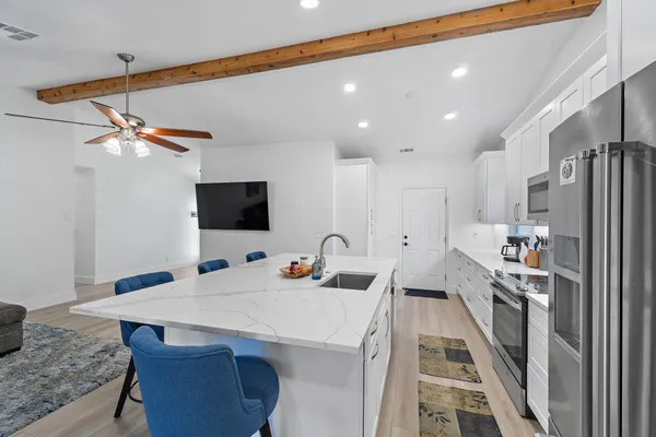 a kitchen that has a lot of cabinets a sink and appliances in it
