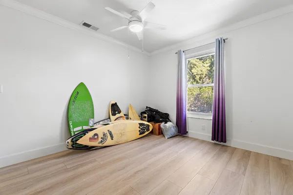 an empty room with wooden floor and windows