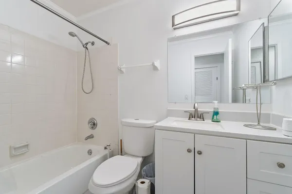 an empty room with wooden floor cabinet and windows