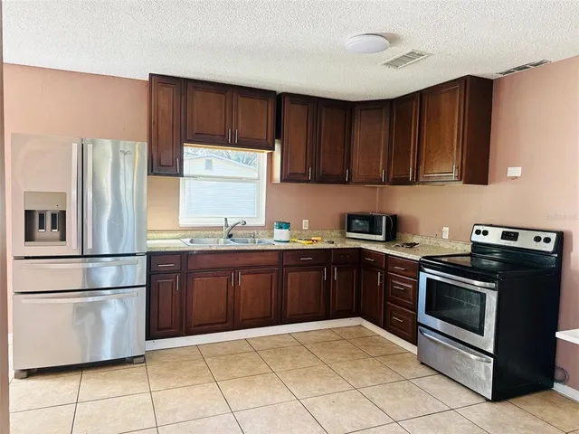 a kitchen with granite countertop wooden cabinets and stainless steel appliances