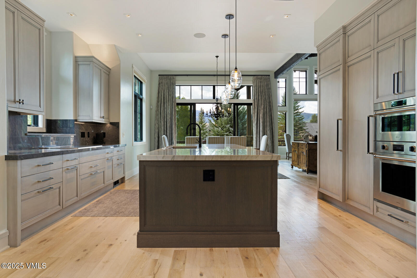 130 Fall Creek Road Edwards, CO 81632 - Photo 9 of 52 a kitchen with kitchen island granite countertop a stove a sink a refrigerator and white cabinets with wooden floor