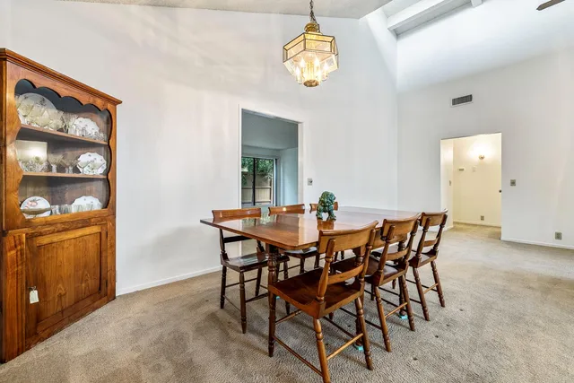 a view of a dining room with furniture and chandelier