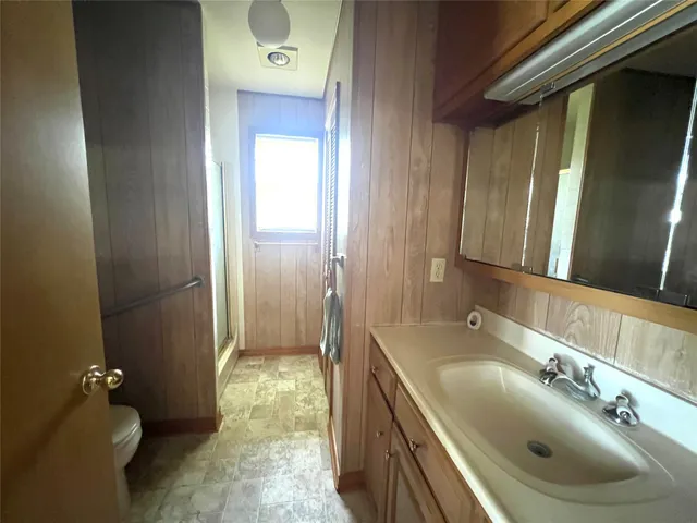 a bathroom with a granite countertop sink a toilet and a mirror