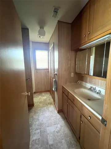 an empty room with a chandelier fan and windows