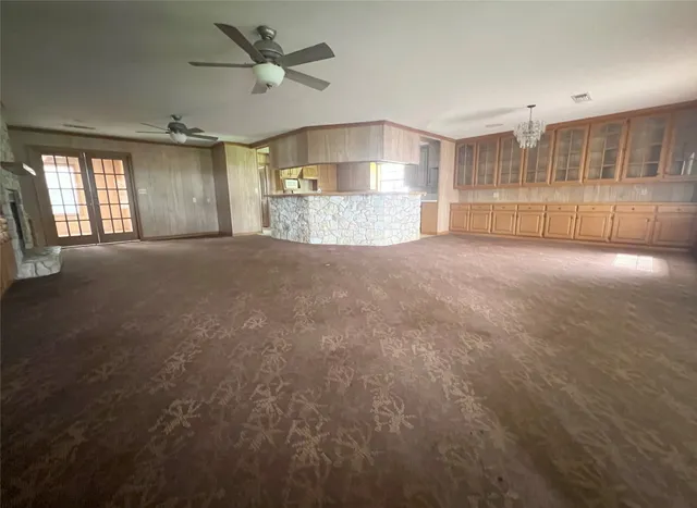 a view of empty room with windows and ceiling fan